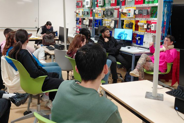 Les bénéficiaires du programme sont dans une salle en train d'écouter une collaboratrice FM parler